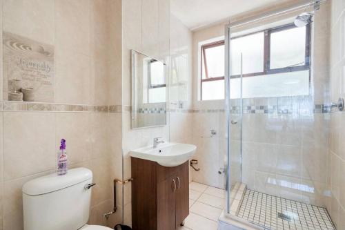 uma casa de banho com um WC, um lavatório e um chuveiro em Lovely 2-bedroom apartment, with an amazing view em Durban