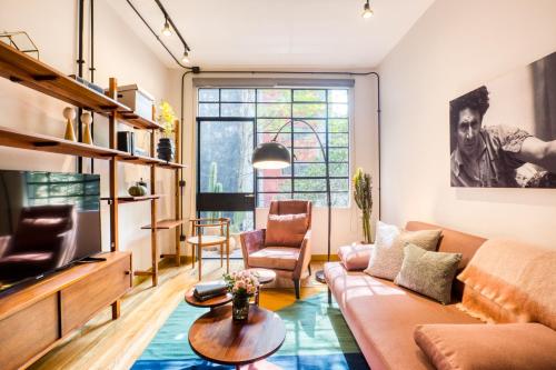 a living room with a couch and a tv at Casa Miravalle in Mexico City