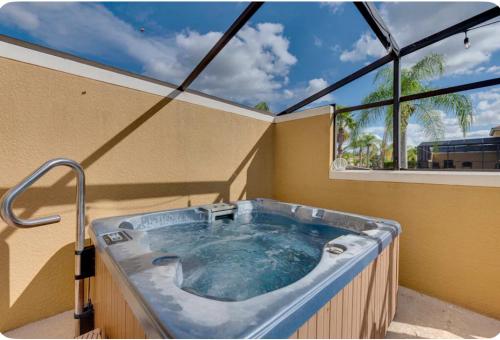 a hot tub in a room with a large window at Welcome to Villa Azul, your home away from home! in Kissimmee