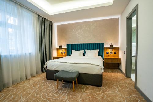 una habitación de hotel con una cama grande y una silla en ATLAS Hotel en Timisoara