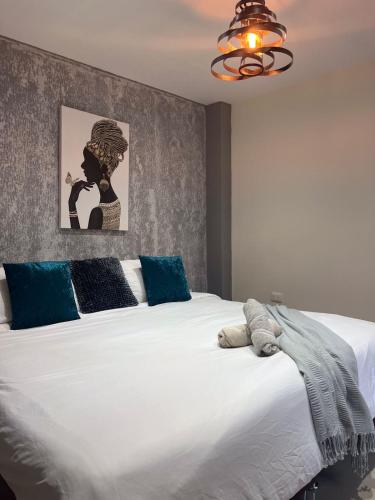 a bedroom with a large white bed with blue pillows at Montes De Beraka in Minca