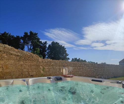 bañera de hidromasaje frente a una pared de piedra en Ballium Luxury Relais, en Avola