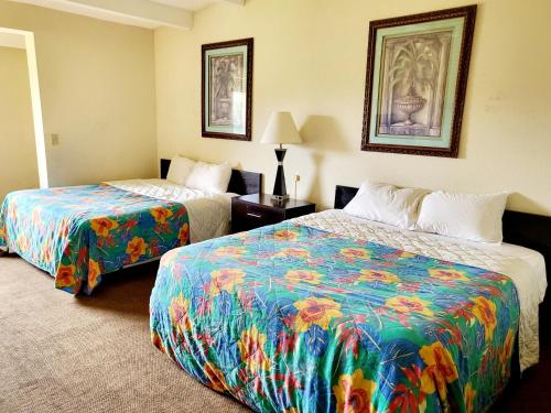 a hotel room with two beds with colorful sheets at Metro Inn & Suites in Jacksonville