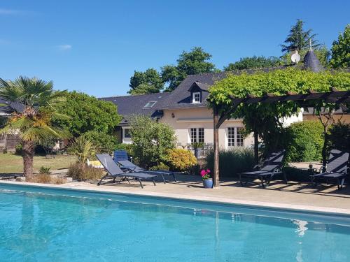 une maison avec une piscine devant une maison dans l'établissement Gîte cosy près du Mans avec jardin, piscine et parking, idéal pour 4 pers. - FR-1-410-388, à Changé