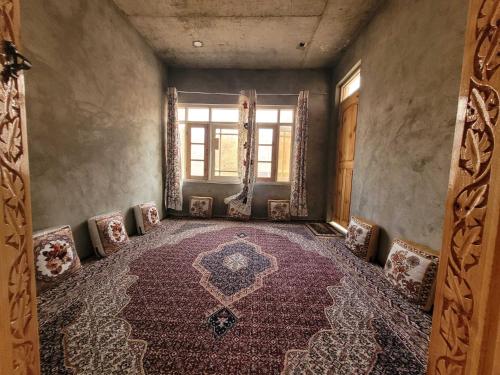 an empty room with chairs and a large rug at POP Home Sharik Homestay 