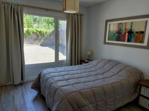 1 dormitorio con cama y ventana grande en Antón SMAndes en San Martín de los Andes
