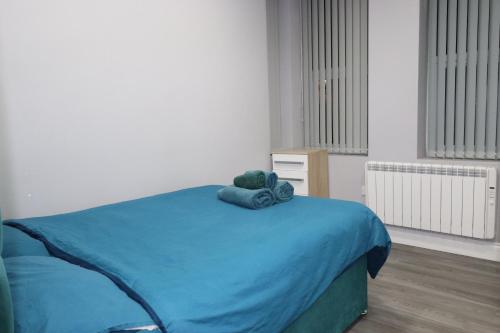 Ground Floor 1 Bed Flat Dartford- 1 - Fully Equipped - Fibre Wifi في دارتفورد: غرفة نوم مع سرير وبطانية زرقاء