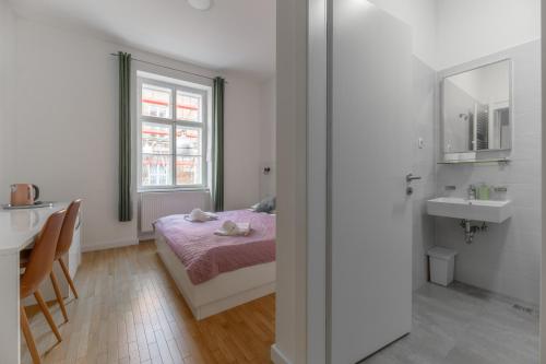 1 dormitorio con cama, lavabo y espejo en Niva Rooms & Studio Apartment, en Zagreb