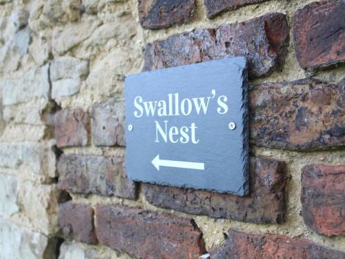 a sign on a brick wall that reads swallows nest at Swallow's Nest in Gainsborough