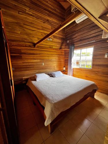 a bedroom with a bed in a wooden room at Las cabañas del Francés in Alto Boquete