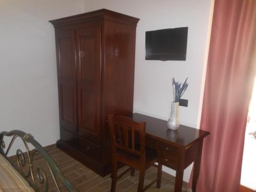 a room with a wooden cabinet and a table with a desk sidx sidx at Agriturismo Nona Rosa in Gravedona