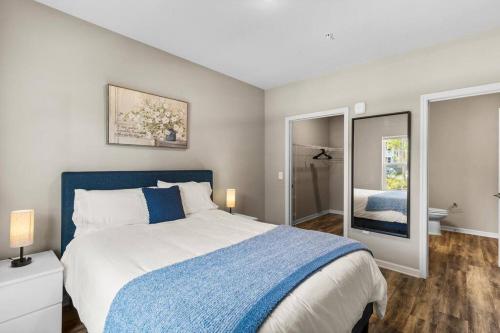 sypialnia z niebiesko-białym łóżkiem i łazienką w obiekcie Refined 2 Bedroom Retreat: Pool, Gym, Laundry w mieście Melbourne