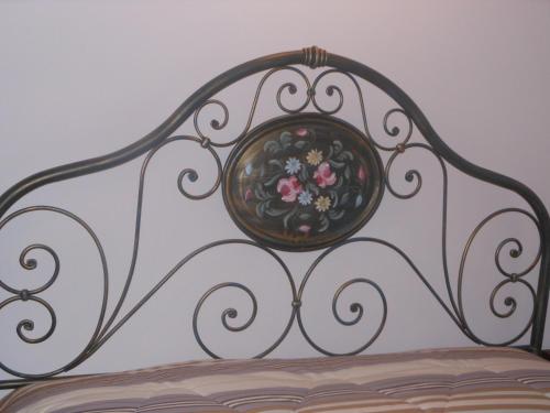 a metal bed with a bowl of flowers on it at Agriturismo Nona Rosa in Gravedona