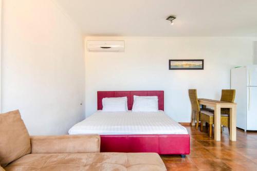a bedroom with a bed and a couch at Studios with beautiful sea view in Willemstad