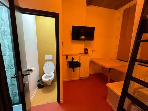 een badkamer met een toilet in een oranje kamer bij BED Pepin in Namen