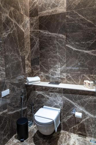 a bathroom with a toilet in a tiled wall at Ishq Colombo in Colombo