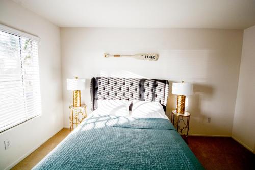 um quarto com uma cama com um cobertor verde e 2 candeeiros em Bay Views & Gaslamp/Little Italy/Convention 1BD em San Diego