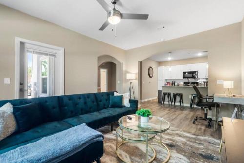 メルボルンにあるChic 2BR/2BA Condo: Pool & More!の青いソファとテーブルのあるリビングルーム