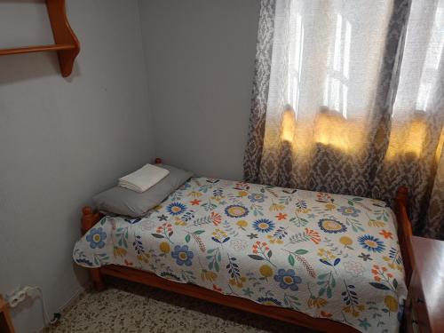 Una cama pequeña en una habitación con ventana. en Rooms Malaga, en Málaga