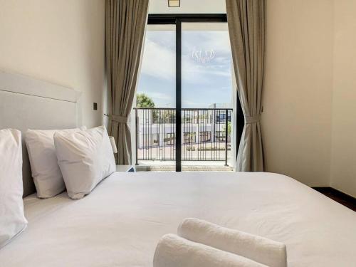 1 dormitorio con 1 cama grande y ventana grande en Key View - Villa, Casa Flores, en Dubái