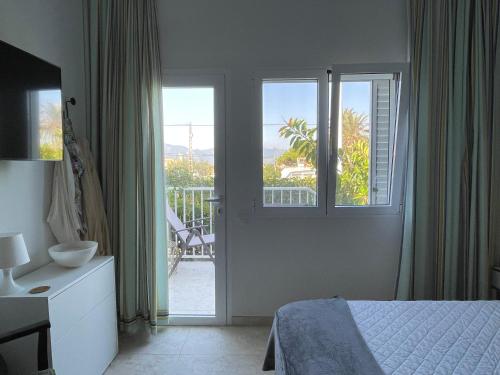 a bedroom with a bed and a view of a balcony at Chalet Las Brisas in Cullera