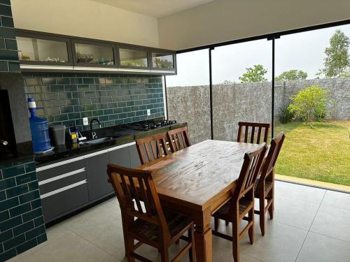 a kitchen with a wooden table and some chairs at Casa Bela in Bonito