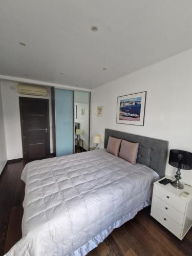 a bedroom with a large white bed and a night stand at Villa Castoria in Saint-Germain-en-Laye