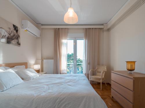 una camera da letto con un grande letto bianco e una finestra di Marousi Cozy Apartment ad Atene