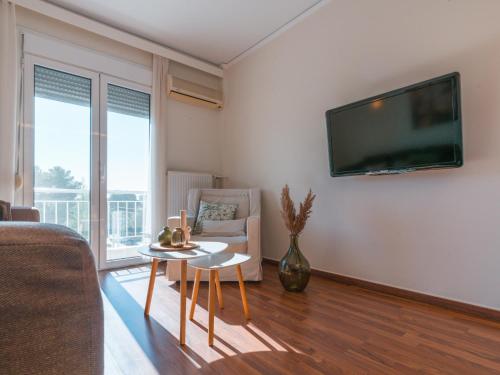 a living room with a couch and a tv on the wall at Marousi Cozy Apartment in Athens