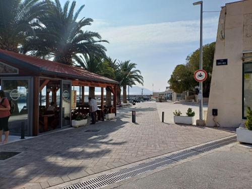 a street with a building and palm trees on a street at Lina in Gradac