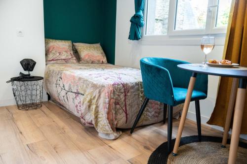 a bedroom with a bed and a table and a chair at BLUE HOME in Fougères