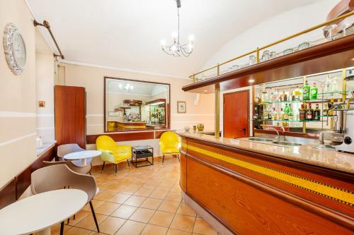 a bar with yellow chairs and a counter at Hotel Castello in Turin
