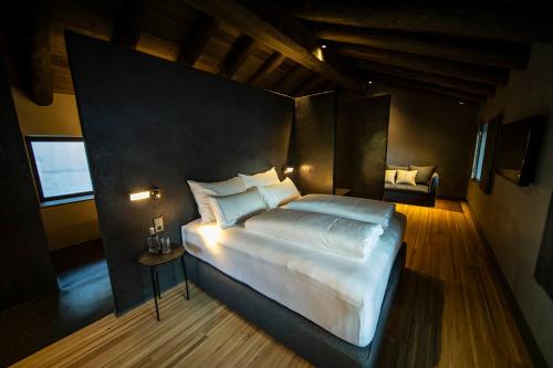 Les Pardines 1819 Mountain suites & SPA في انكامب: غرفة نوم مع سرير أبيض كبير في غرفة