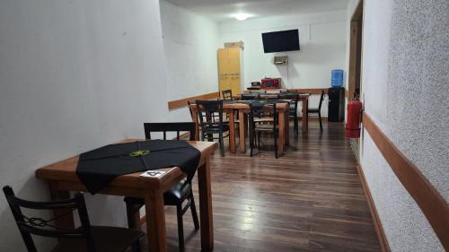 uma sala de jantar com mesas e cadeiras e uma televisão em Residencial F y V Spa em Rancagua