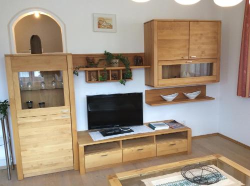 a living room with a tv and wooden cabinets at Klammer Gabi in Obertilliach