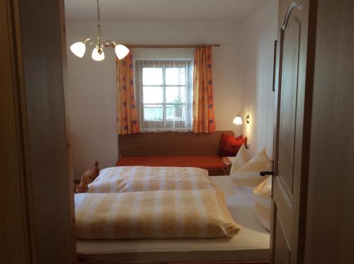 a bedroom with a bed and a window at Klammer Gabi in Obertilliach