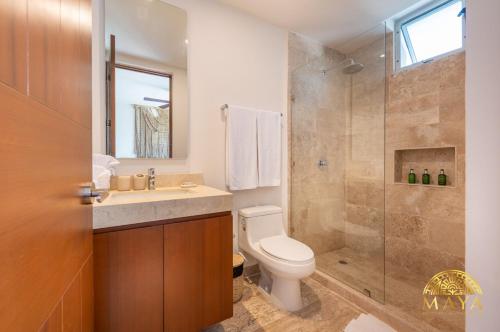 トゥルムにあるNHOA 307B Lux 1BR Condo Pool View in Aldea Zamaのトイレ、洗面台、シャワー付きのバスルーム