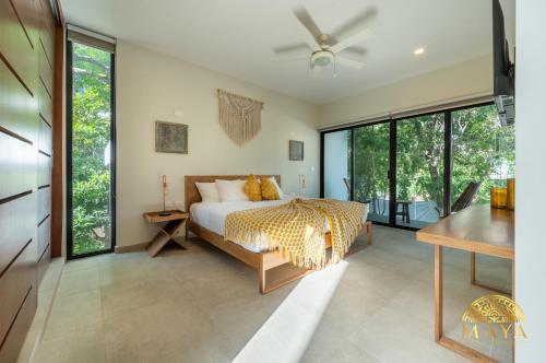 a bedroom with a king sized bed and large windows at Selvaterra 201 Lux 2BR Large Condo in Aldea Zama in Tulum