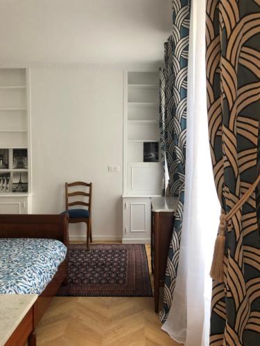 une chambre avec un lit, un bureau et une chaise dans l'établissement Apartment quartier St Louis - 10 mins walking Château Versailles, à Versailles
