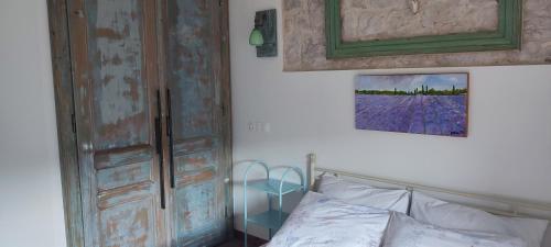 a bedroom with a bed and a painting on the wall at Apartmani Pelješac Sova in Sreser