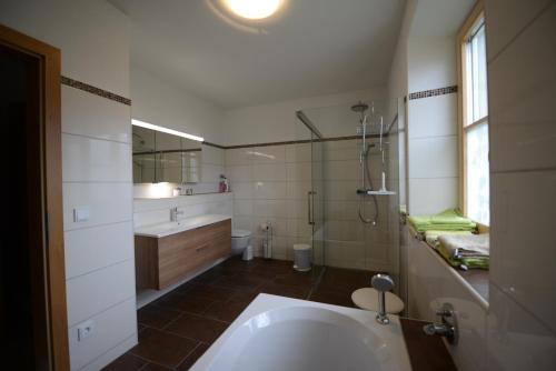 y baño con bañera y lavamanos. en Weinbachbauer - Urlaub am Bauernhof, en St. Wolfgang