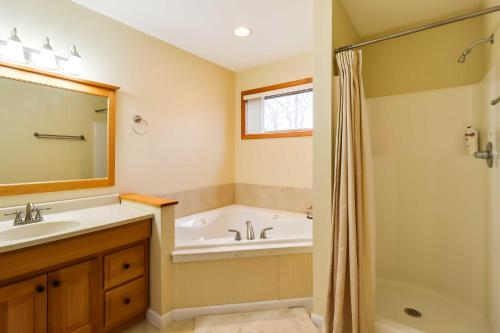 een badkamer met een bad, een wastafel en een douche bij Lakefront Poconos Family Home with Community Pool! in Pocono Lake