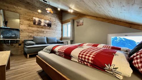 a bedroom with a bed and a couch in a room at Berggasthaus Eggberge - Boutique Mountain Hotel - Access via Cablecar in Altdorf
