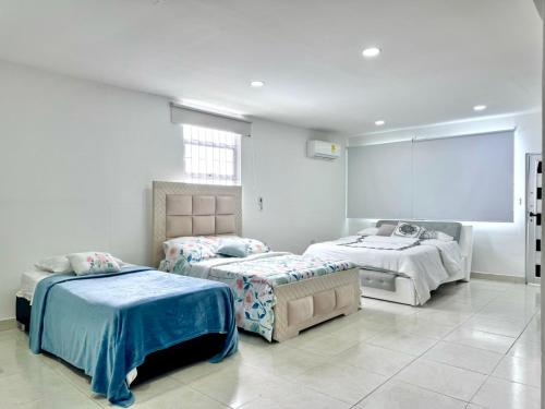 a bedroom with two beds and a large window at HELENE HOUSE in Sincelejo