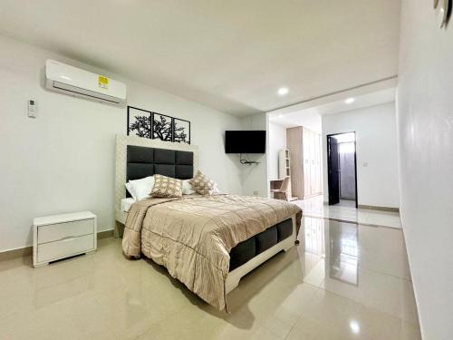 a bedroom with a bed and a television in it at HELENE HOUSE in Sincelejo