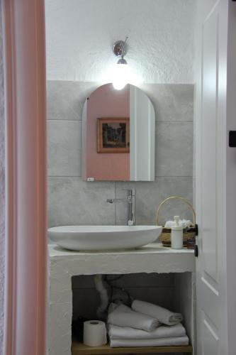 La salle de bains est pourvue d'un lavabo, d'un miroir et de serviettes. dans l'établissement BADEMİÇİ OTEL, à Alaçatı