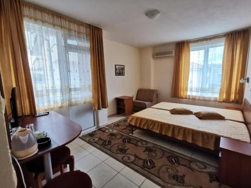 1 dormitorio con 1 cama, escritorio y ventanas en Guest House Georgieva Ravda en Ravda