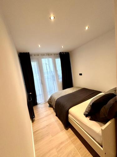 a bedroom with a bed in a room with windows at My Haus European Commision in Brussels