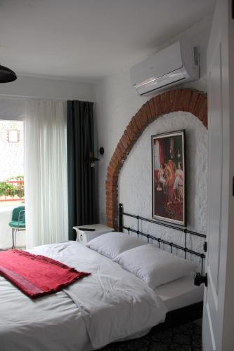 - une chambre avec 2 lits et un mur en briques dans l'établissement BADEMİÇİ OTEL, à Alaçatı