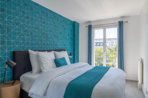 een slaapkamer met een blauwe accentmuur en een bed bij L'Évasion Bleue à Disneyland Paris - 6 personnes in Chessy
